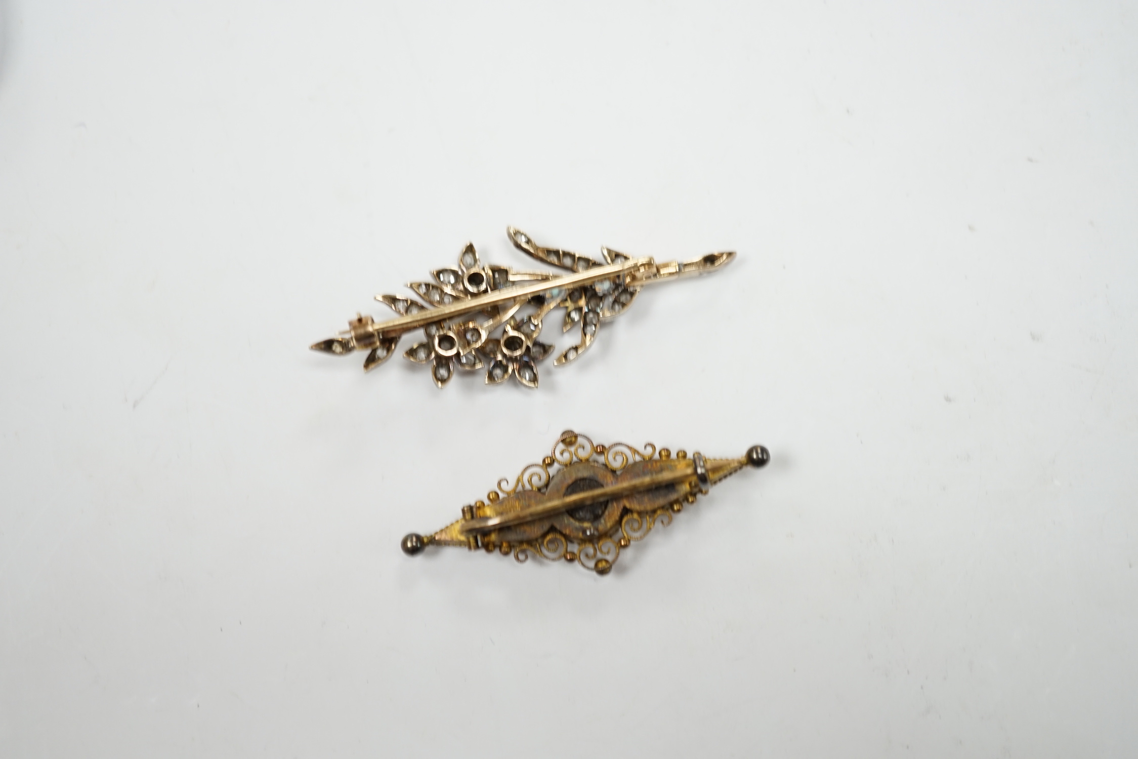 A late Victorian, yellow metal, white metal and diamond cluster set foliate spray brooch, 53mm, together with a Victorian 15ct gold and singe stone diamond set bar brooch, gross weight 11.5 grams.